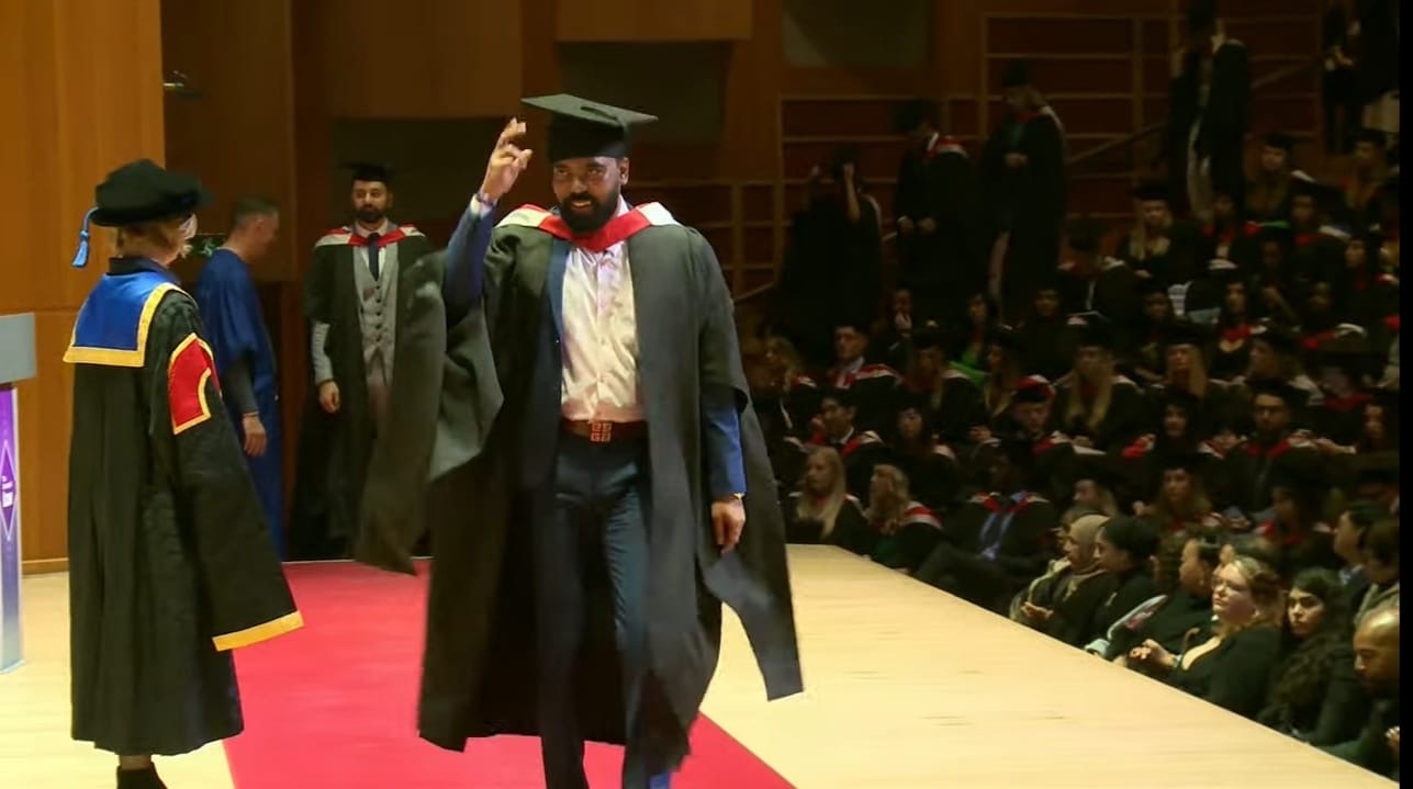 Kushagra Verma crossing the stage in cap and gown at The University of Law graduation ceremony