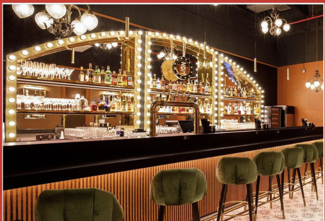 Hitchki bar with backlit arches, brass detailing and velvet bar stools